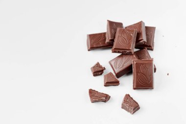 Beyaz arka planda izole edilmiş sütlü çikolata parçaları, beyaz arkaplanda izole edilmiş çikolatayı kapat