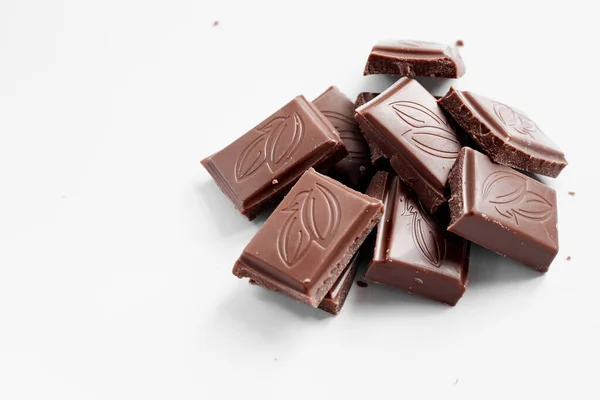 Beyaz arka planda izole edilmiş sütlü çikolata parçaları, beyaz arkaplanda izole edilmiş çikolatayı kapat