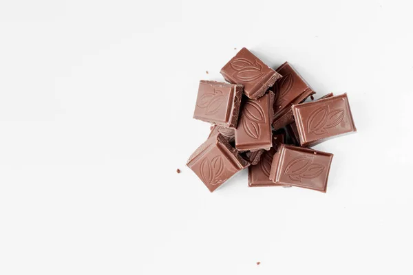 Mjölkchoklad Bitar Isolerad Vit Bakgrund Från Ovanifrån Närbild Chokladkaka Isolerad — Stockfoto