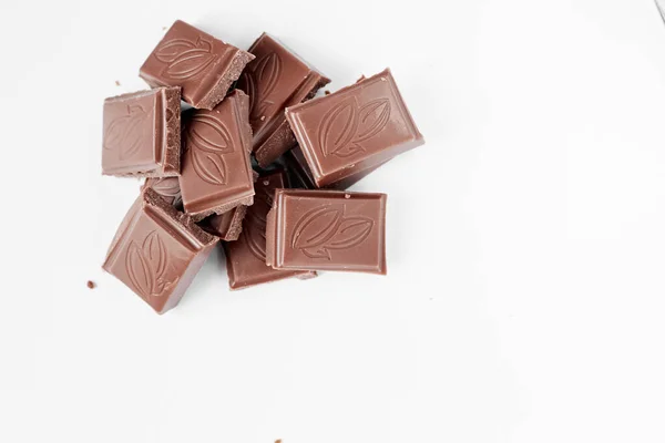 Beyaz arka planda izole edilmiş sütlü çikolata parçaları, beyaz arkaplanda izole edilmiş çikolatayı kapat