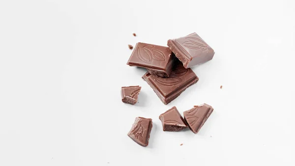 Beyaz arka planda izole edilmiş sütlü çikolata parçaları, beyaz arkaplanda izole edilmiş çikolatayı kapat