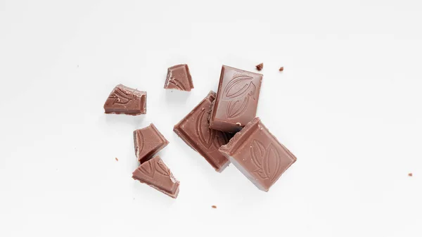 Beyaz arka planda izole edilmiş sütlü çikolata parçaları, beyaz arkaplanda izole edilmiş çikolatayı kapat