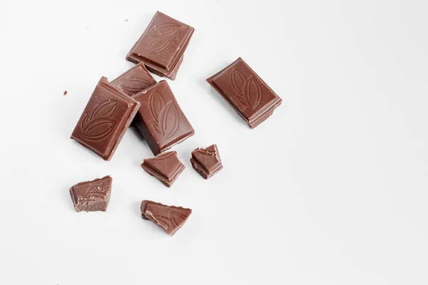 Beyaz arka planda izole edilmiş sütlü çikolata parçaları, beyaz arkaplanda izole edilmiş çikolatayı kapat