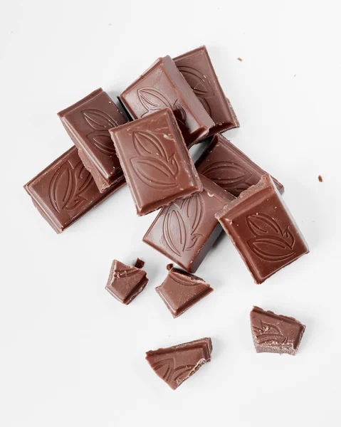 Beyaz arka planda izole edilmiş sütlü çikolata parçaları, beyaz arkaplanda izole edilmiş çikolatayı kapat