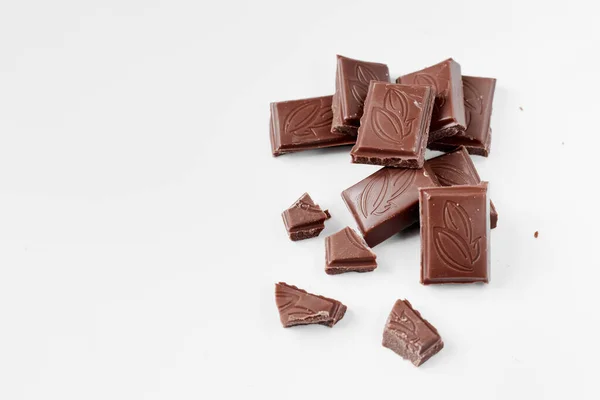 하얀 배경 위에서 분리 된 밀크 초콜릿 조각들이 하얀 배경 위에 분리되어 초콜릿 바를 닫는다 — 스톡 사진