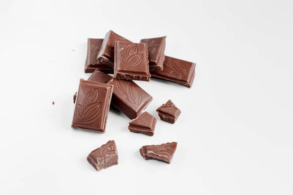 Beyaz arka planda izole edilmiş sütlü çikolata parçaları, beyaz arkaplanda izole edilmiş çikolatayı kapat