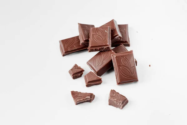 Κομμάτια σοκολάτας γάλακτος που απομονώνονται σε λευκό φόντο από πάνω, κλείστε μια σοκολάτα που απομονώνεται σε λευκό φόντο — Φωτογραφία Αρχείου