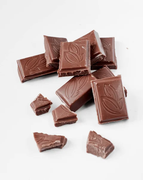Pedaços de chocolate de leite isolados no fundo branco da vista superior, feche uma barra de chocolate isolada no fundo branco — Fotografia de Stock