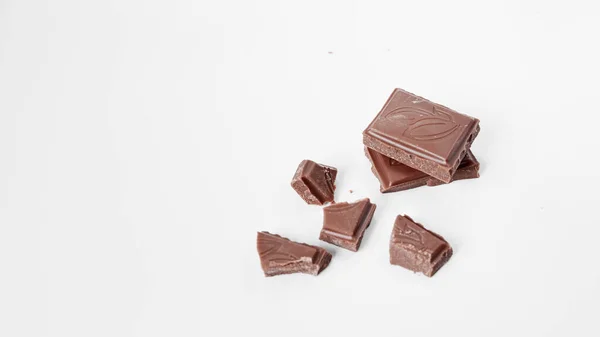 Beyaz arka planda izole edilmiş sütlü çikolata parçaları, beyaz arkaplanda izole edilmiş çikolatayı kapat