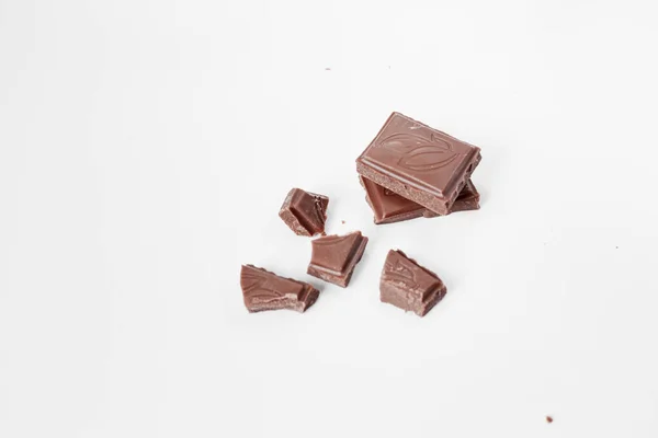 Beyaz arka planda izole edilmiş sütlü çikolata parçaları, beyaz arkaplanda izole edilmiş çikolatayı kapat