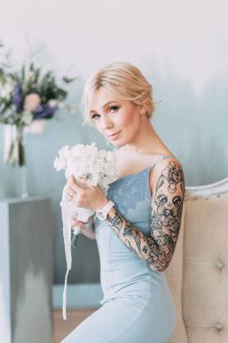 Çiçek ve dekorla düğün kemerinin önünde güzel bir gelin. Buket ellerde ve detaylarda. Kız mutlu, gülümsüyor ve dans ediyor. Modern tarzda bir gelinlik hayal et.