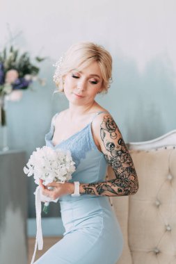 Çiçek ve dekorla düğün kemerinin önünde güzel bir gelin. Buket ellerde ve detaylarda. Kız mutlu, gülümsüyor ve dans ediyor. Modern tarzda bir gelinlik hayal et.