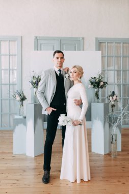 Güzel düğün ışık mavi renklerde Avrupa tarzı. Alışılmadık bir kemer, ilham iki arka planda stüdyoda. Gelin ve yakışıklı damat gülüyor