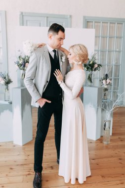 Güzel düğün ışık mavi renklerde Avrupa tarzı. Alışılmadık bir kemer, ilham iki arka planda stüdyoda. Gelin ve yakışıklı damat gülüyor