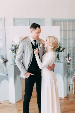 Güzel düğün ışık mavi renklerde Avrupa tarzı. Alışılmadık bir kemer, ilham iki arka planda stüdyoda. Gelin ve yakışıklı damat gülüyor