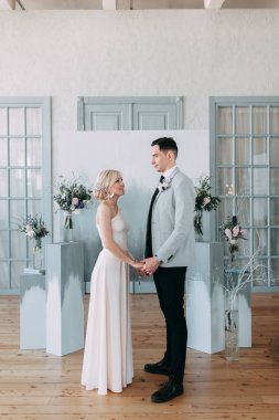 Güzel düğün ışık mavi renklerde Avrupa tarzı. Alışılmadık bir kemer, ilham iki arka planda stüdyoda. Gelin ve yakışıklı damat gülüyor