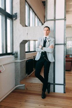 Gelin için bekleyen güzel bir damat toplanması. İç stüdyo fotoğraf çekimi. Düğün Avrupa tarzı. Yakışıklı bir ceket ve pantolon