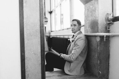 Gelin için bekleyen güzel bir damat toplanması. İç stüdyo fotoğraf çekimi. Düğün Avrupa tarzı. Yakışıklı bir ceket ve pantolon