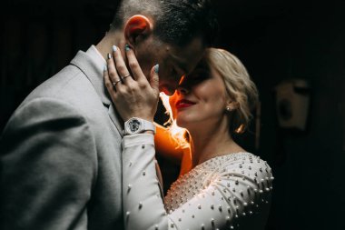 Sokaktaki binanın çatısında çekim düğün öncesi. Gülme, sarılma ve çalışan mutlu çift. Gülümse ve halkı yakışıklı görünüyor. günbatımı evleri ve sokakları