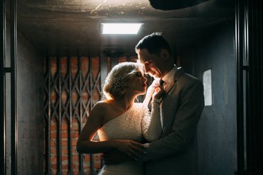 Sokaktaki binanın çatısında çekim düğün öncesi. Gülme, sarılma ve çalışan mutlu çift. Gülümse ve halkı yakışıklı görünüyor. günbatımı evleri ve sokakları