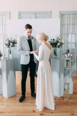 Güzel düğün ışık mavi renklerde Avrupa tarzı. Alışılmadık bir kemer, ilham iki arka planda stüdyoda. Gelin ve yakışıklı damat gülüyor