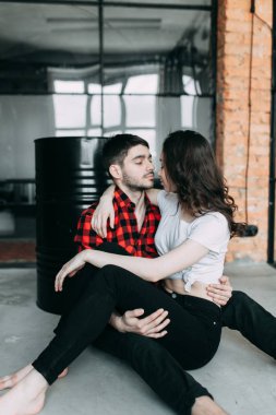 bir fotoğraf karizmatik çifte Avrupa tarzında vur. Sarılma ve birbirine bakarak gülümsüyordu. Geçici belgili tanımlık bakmak ve ışık havadar elbise kız. Studio loft ve güzel bir kız