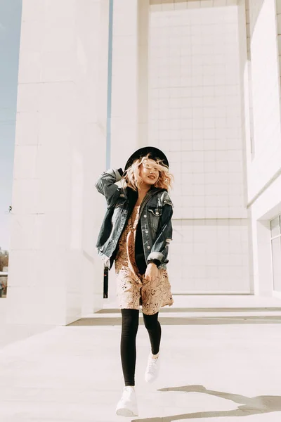 Güzel şık kız, sokak fotoğraf çekimi gözlük ve şapka ile. Gülüyor, gülümsüyor ve yuvarlak çalışır. Amerikan içinde belgili tanımlık fotoğraf işleme. Lookbook koleksiyonu sokak stili