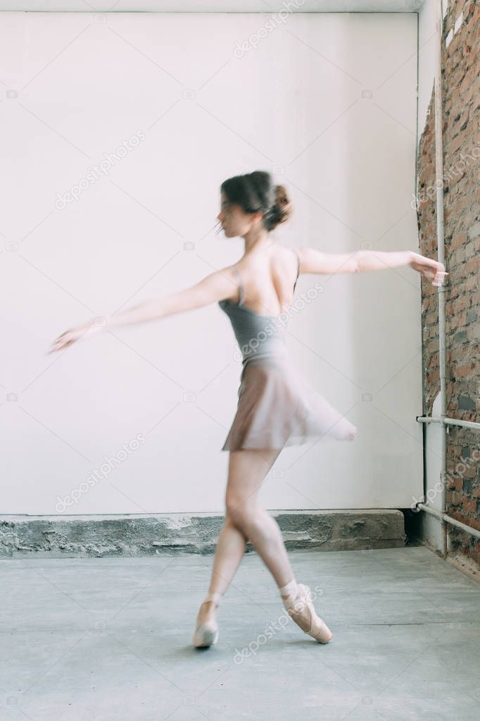 A young ballerina is getting ready, stretched and dancing. Poses in ballet. Photo shoot in the loft Studio. Russian Ballerina at the bench. ballet flats and dance dress