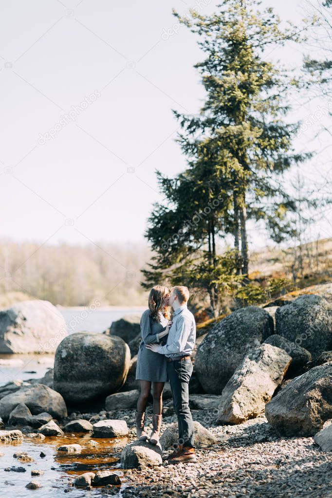 Pre-wedding photo shoot in the forest in nature, in the form of walking and traveling. Beauty of the North and Russia. Loving people and beautiful scenery. They laugh, sit and smile. Beautiful couple