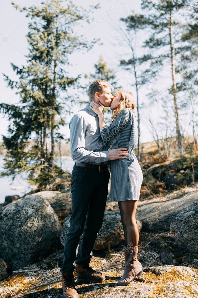 Pre-wedding photo shoot in the forest in nature, in the form of walking and traveling. Beauty of the North and Russia. Loving people and beautiful scenery. They laugh, sit and smile. Beautiful couple