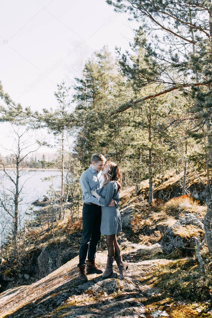 Pre-wedding photo shoot in the forest in nature, in the form of walking and traveling. Beauty of the North and Russia. Loving people and beautiful scenery. They laugh, sit and smile. Beautiful couple