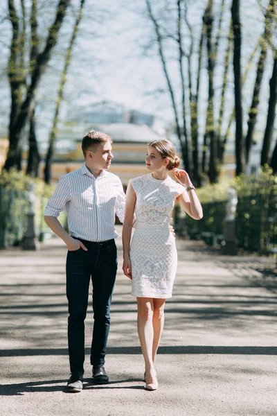 愛情と幸せの晴れた日に公園の美しい若いカップル 歩くし 一緒に笑います 自然に撮影前の結婚式 有名人のような服でエレガントなスタイル — ストック写真