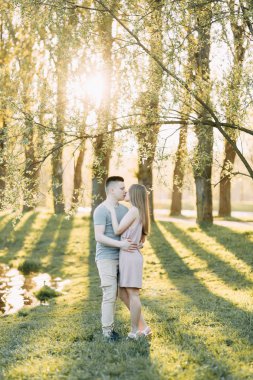 Güzel genç çift parkta güneşli bir günde, sevgi dolu ve mutlu. Yürümek ve gülmek. Doğada çekim düğün öncesi. Casual tarzda işleme giyim ve Avrupa