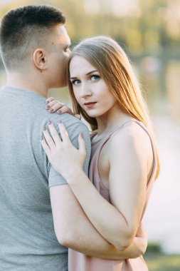 Güzel genç çift parkta güneşli bir günde, sevgi dolu ve mutlu. Yürümek ve gülmek. Doğada çekim düğün öncesi. Casual tarzda işleme giyim ve Avrupa