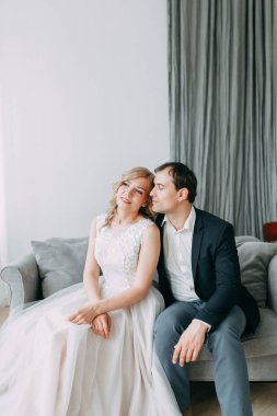 Güzel çift düğün fotoğraf çekimi. Studio loft Avrupa tarzında, parlak ve büyük pencereler ile. Sevgi dolu insanlar mutlu yüzler ile. Gelin buketi ve şık dekoratif.