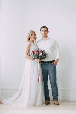 Güzel çift düğün fotoğraf çekimi. Studio loft Avrupa tarzında, parlak ve büyük pencereler ile. Sevgi dolu insanlar mutlu yüzler ile. Gelin buketi ve şık dekoratif.