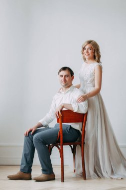 Güzel çift düğün fotoğraf çekimi. Studio loft Avrupa tarzında, parlak ve büyük pencereler ile. Sevgi dolu insanlar mutlu yüzler ile. Gelin buketi ve şık dekoratif.