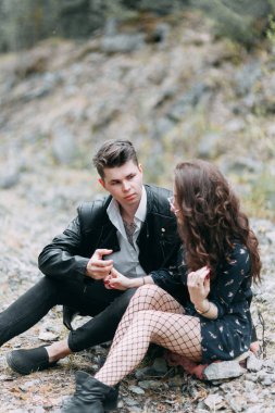 Genç şık çift ormanda, Park çevresinde çalışan ve gülüyor. Modern insan bir yürüyüş. Dövmeli güzel kız. Sevgi dolu genç adam ve kız. dağ Park çam ormanı ile