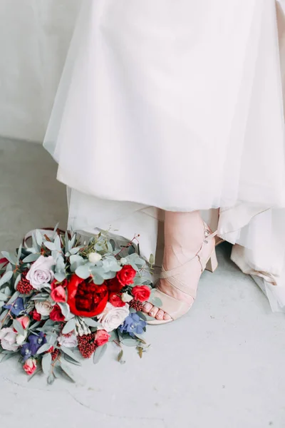 明るいスタイリッシュなスタジオで結婚式のドレスで美しい花嫁 ヨーロッパ風の結婚式 手に装飾と花束 若い女の子が立って座ってポーズをとって — ストック写真