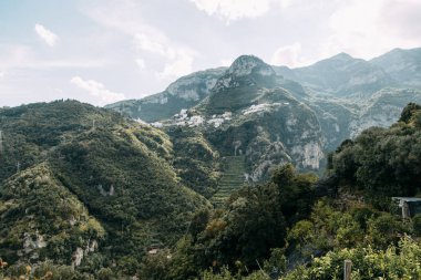 Amalfi coast ve dağ yamaçlarında limon bahçeleri ile. Panoramik şehir ve doğa İtalya. Manzaralar akşam ve dolambaçlı yollar. Deniz ve kayalar üzerinde gökyüzü.