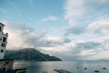Amalfi coast ve dağ yamaçlarında limon bahçeleri ile. Panoramik şehir ve doğa İtalya. Manzaralar akşam ve dolambaçlı yollar. Deniz ve kayalar üzerinde gökyüzü.