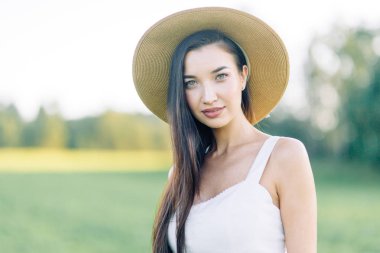 Bir şapka ve yaz elbise, alanın üzerinde yürüyen kız. Gülümseyen ve gülüyor, orman ve doğa güzel gün batımı. Beyaz elbise ve çavdar, alanları eğimli. Mutlu traveler, yaşam biçimi.