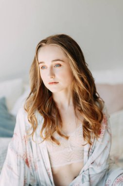 Kız yatakta ve bornoz, sabahın erken saatlerinde uyanır up ve çalışmak hazırlanıyor. Verimli bir gün. Gülümsüyor ve gülüyor. Güneşin doğuşunu yakalamak yatakta yatan. Mutlu sabah yatak odasında.