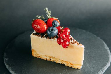 Berry kek bir siyah arka plan, yazarın tatlılar ve hizmet taş. Çikolata, çilek ve krema. Tasarım için Web sitesi