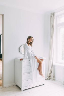 Düğün, Gelin Avrupa tarzı sabah kavramsal. Kadının küçük özel odası elbise ve bir buket çiçek, iç Studio ücretleri. Gelin için beyaz minimalizm