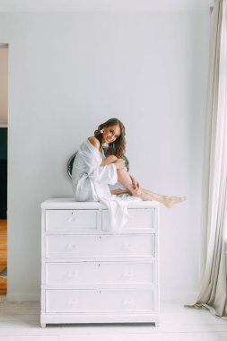 Düğün, Gelin Avrupa tarzı sabah kavramsal. Kadının küçük özel odası elbise ve bir buket çiçek, iç Studio ücretleri. Gelin için beyaz minimalizm