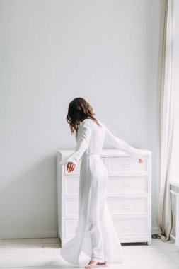 Düğün, Gelin Avrupa tarzı sabah kavramsal. Kadının küçük özel odası elbise ve bir buket çiçek, iç Studio ücretleri. Gelin için beyaz minimalizm