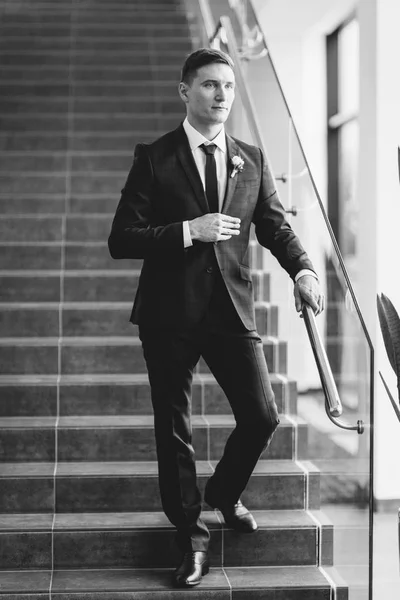 Stylish minimalism in the image of the groom. Black color and European wedding. The preparations of the groom, hotel