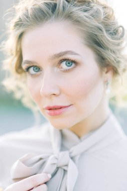 Çiçek ve dekorla düğün kemerinin önünde güzel bir gelin. Buket ellerde ve detaylarda. Kız mutlu, gülümsüyor ve dans ediyor. Modern tarzda bir gelinlik hayal et.