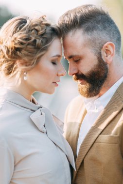 Toplantı yeni evliler köprüde güzel kisses ve hugs. Gün batımında düğün doğada. Tören için iki. Şık modern düğün. Gelin buketi ve dekor.